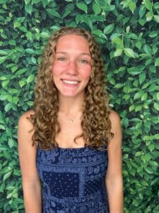 Woman with natural tight curls smiling.